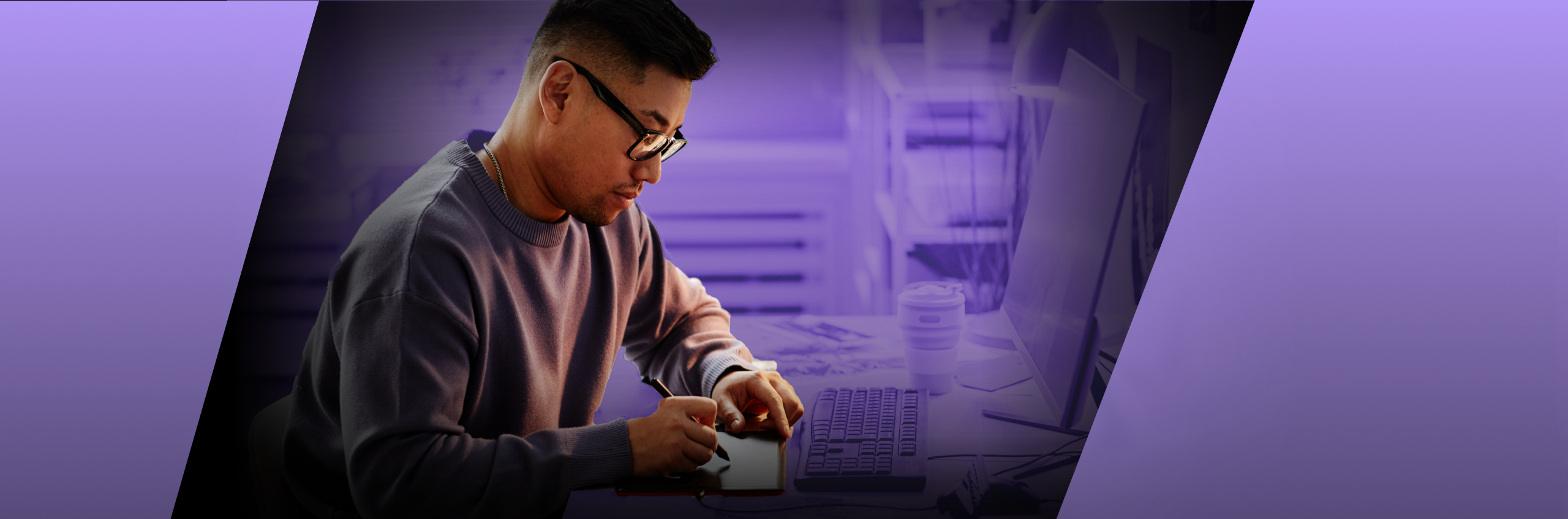 Un joven trabaja con una tableta gráfica en el escritorio.