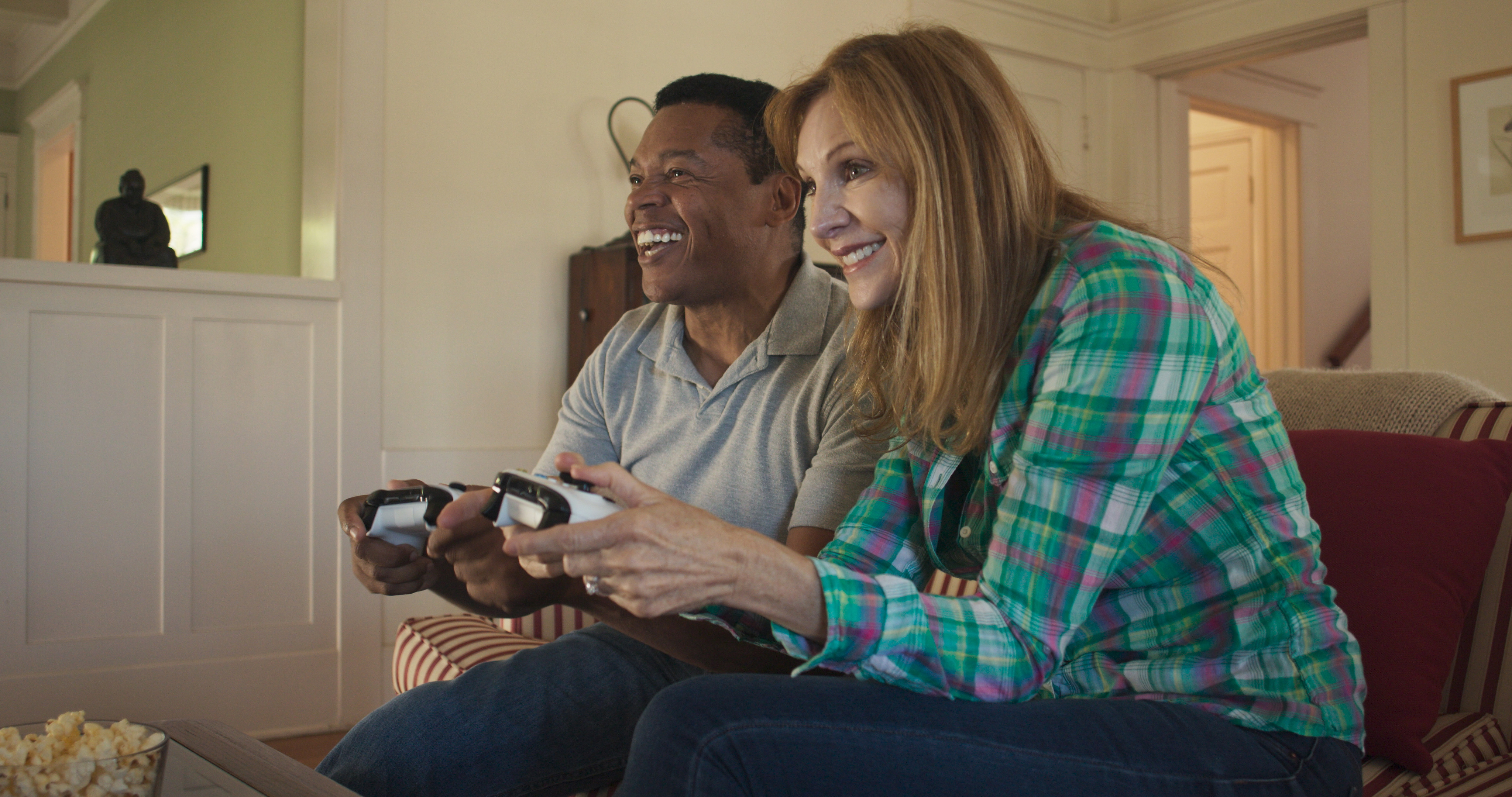 A happy, older couple play video games together.