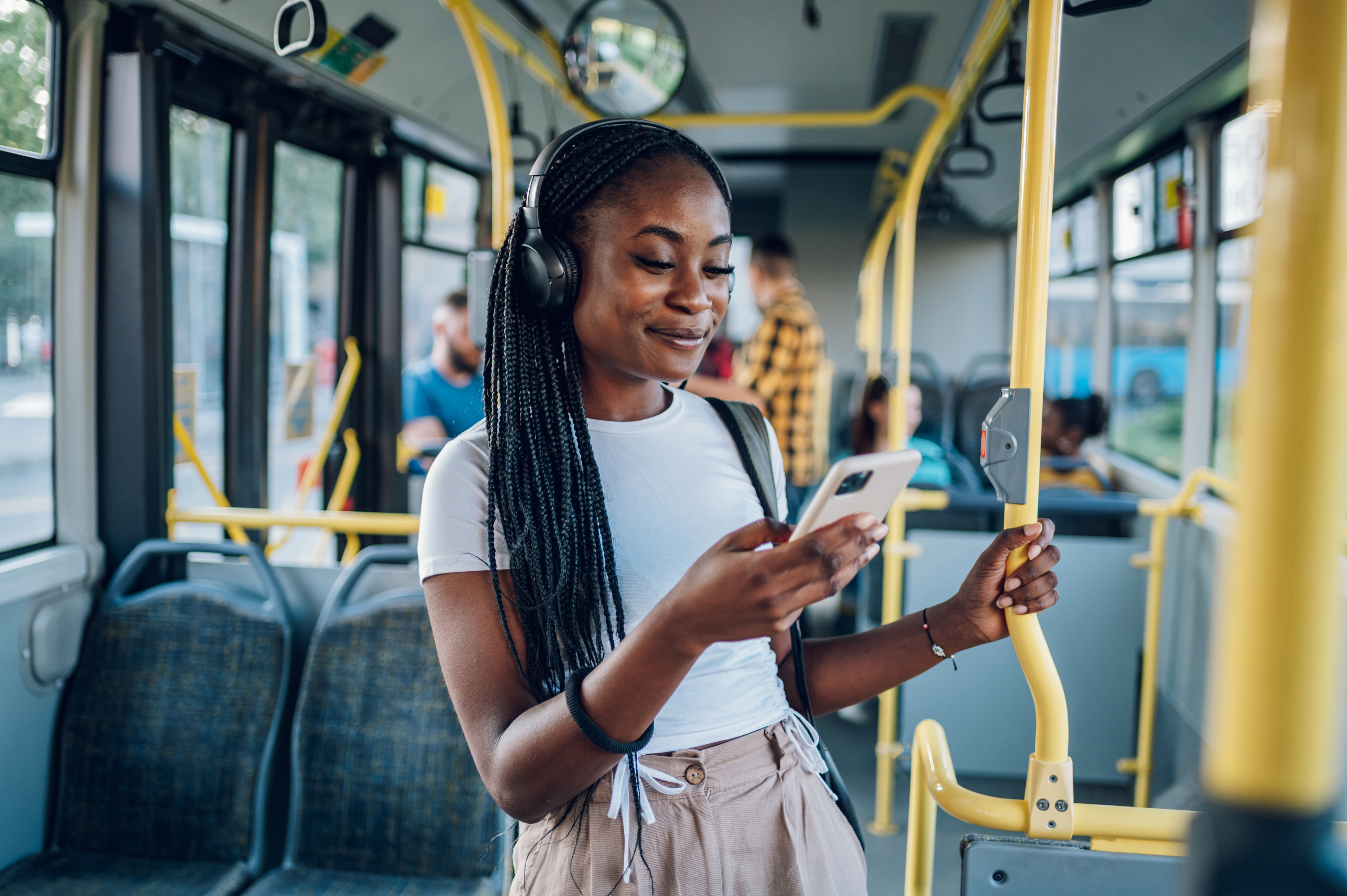 A young woman plays on her phone while riding public transport.