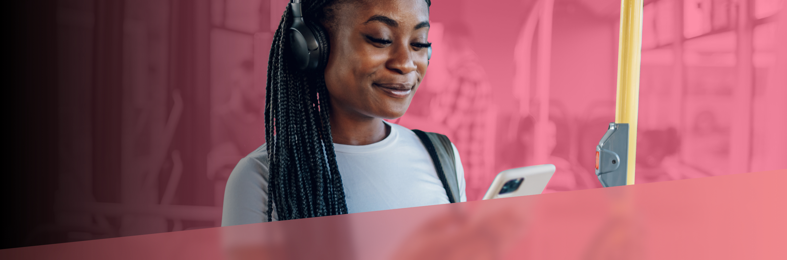 A young woman happily plays games on her phone while taking the bus.