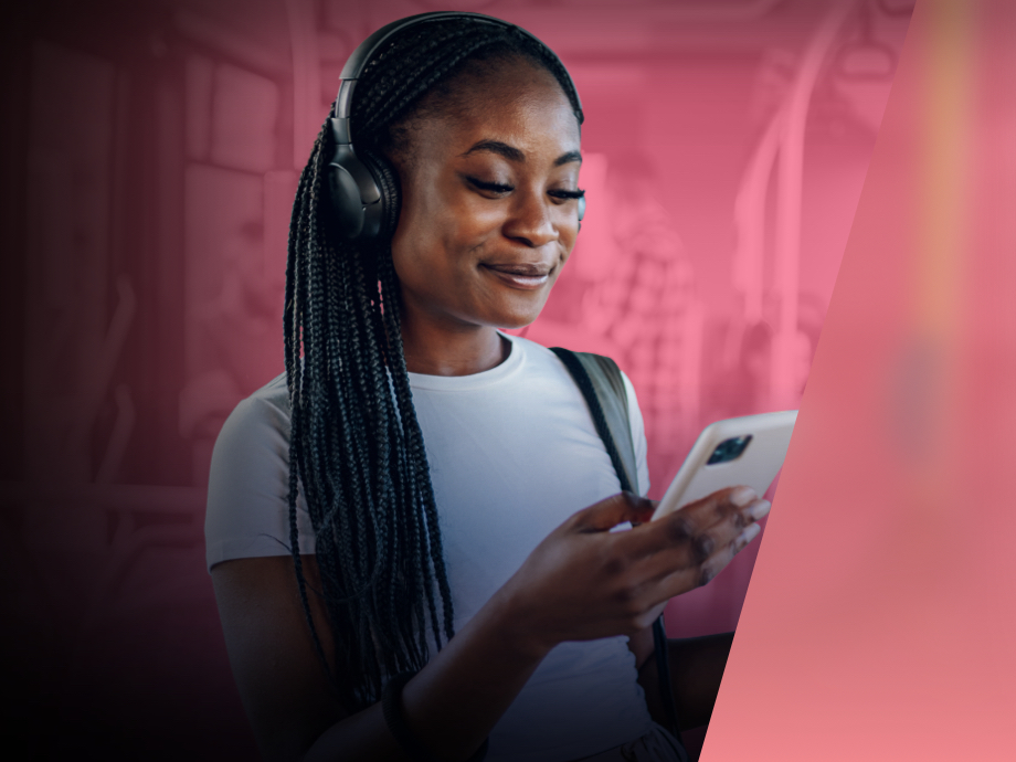 A young woman happily plays games on her phone while taking the bus.